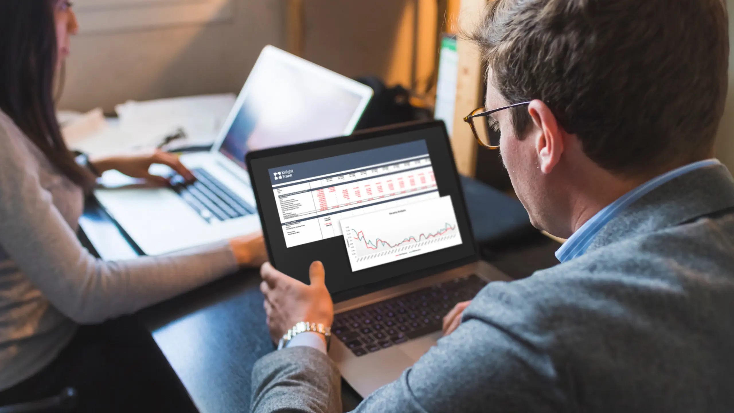 Man looking at graph on laptop